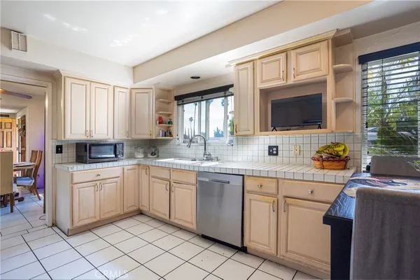 a kitchen with white cabinets a sink and a stove with wooden floor