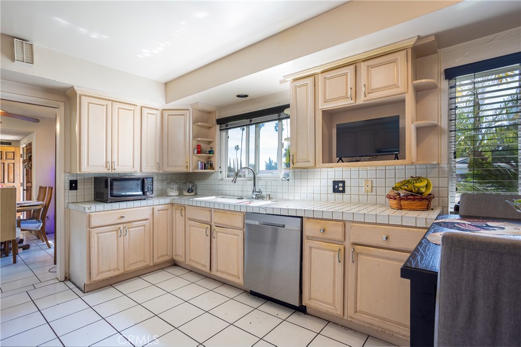 5669 Magnolia Avenue Rialto, CA 92377 - Photo 14 of 35 a kitchen with white cabinets a sink and a stove with wooden floor