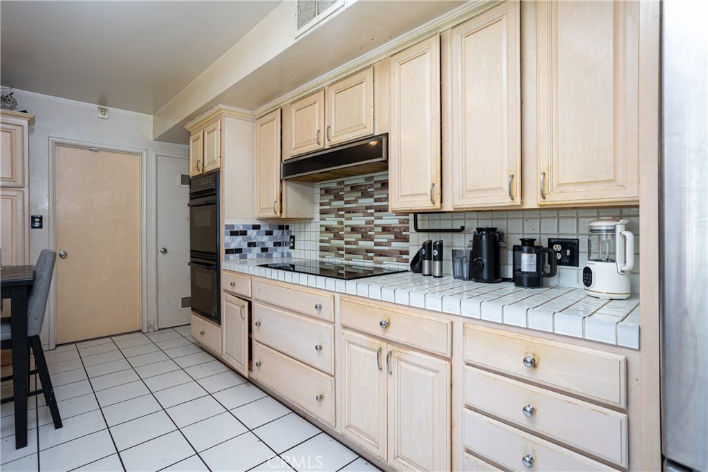 5669 Magnolia Avenue Rialto, CA 92377 - Photo 15 of 35 a kitchen with stainless steel appliances granite countertop a sink a stove and cabinets