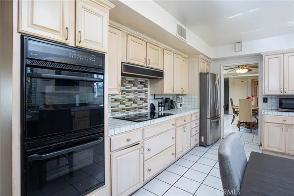 a kitchen with white cabinets and appliances