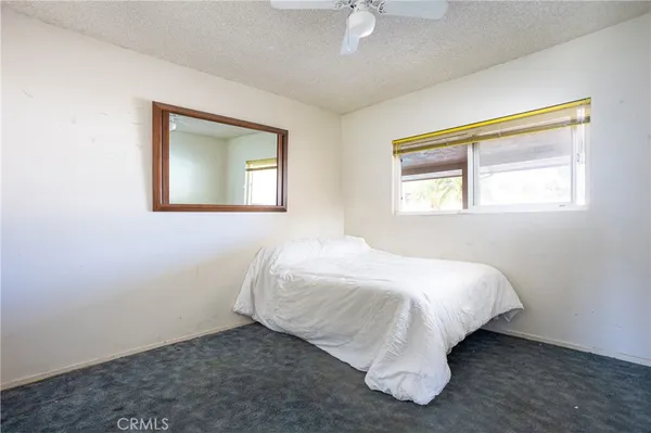 a bed sitting in a bedroom next to a window