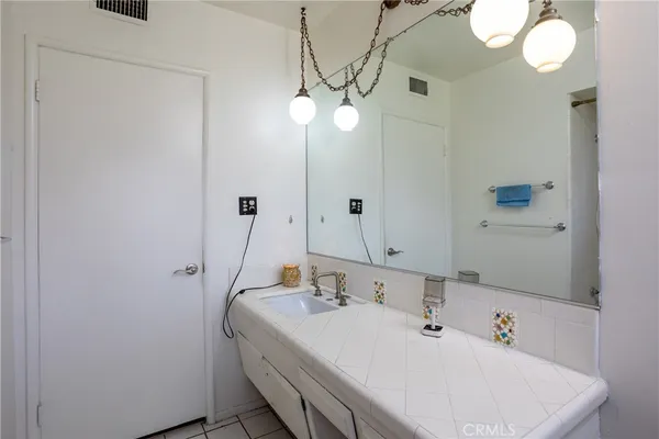 a bathroom with a sink a light fixture and a mirror
