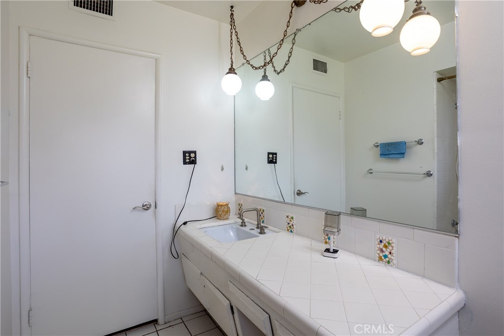 5669 Magnolia Avenue Rialto, CA 92377 - Photo 22 of 35 a bathroom with a sink a light fixture and a mirror