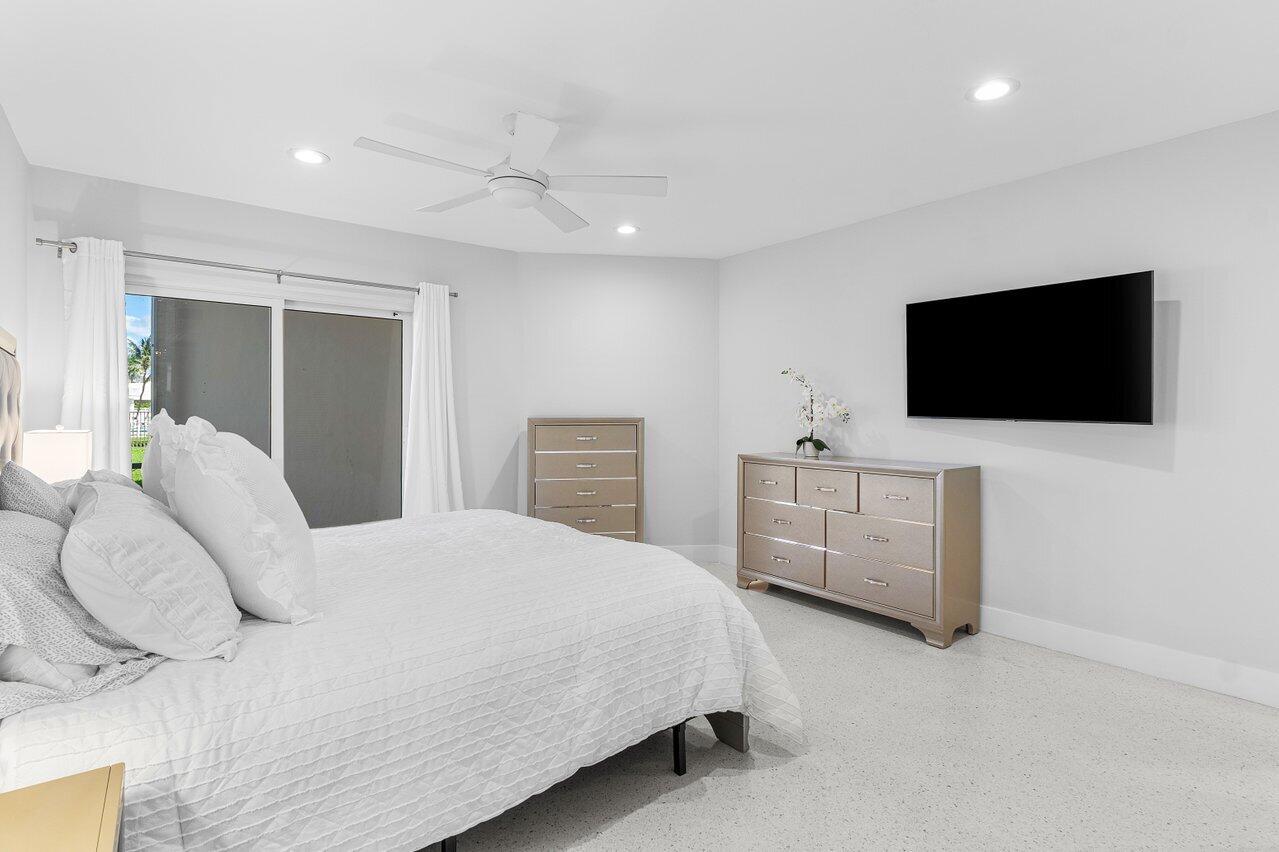 701 Harbour Drive, Unit 103 Boca Raton, FL 33431 - Photo 14 of 39 a bedroom with a bed and a flat screen tv