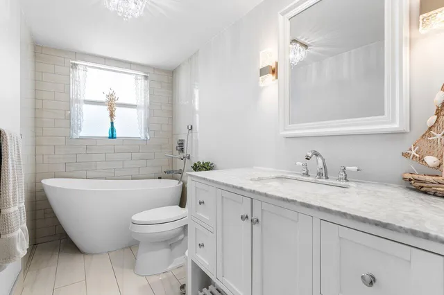 a bathroom with a granite countertop toilet a sink and a mirror