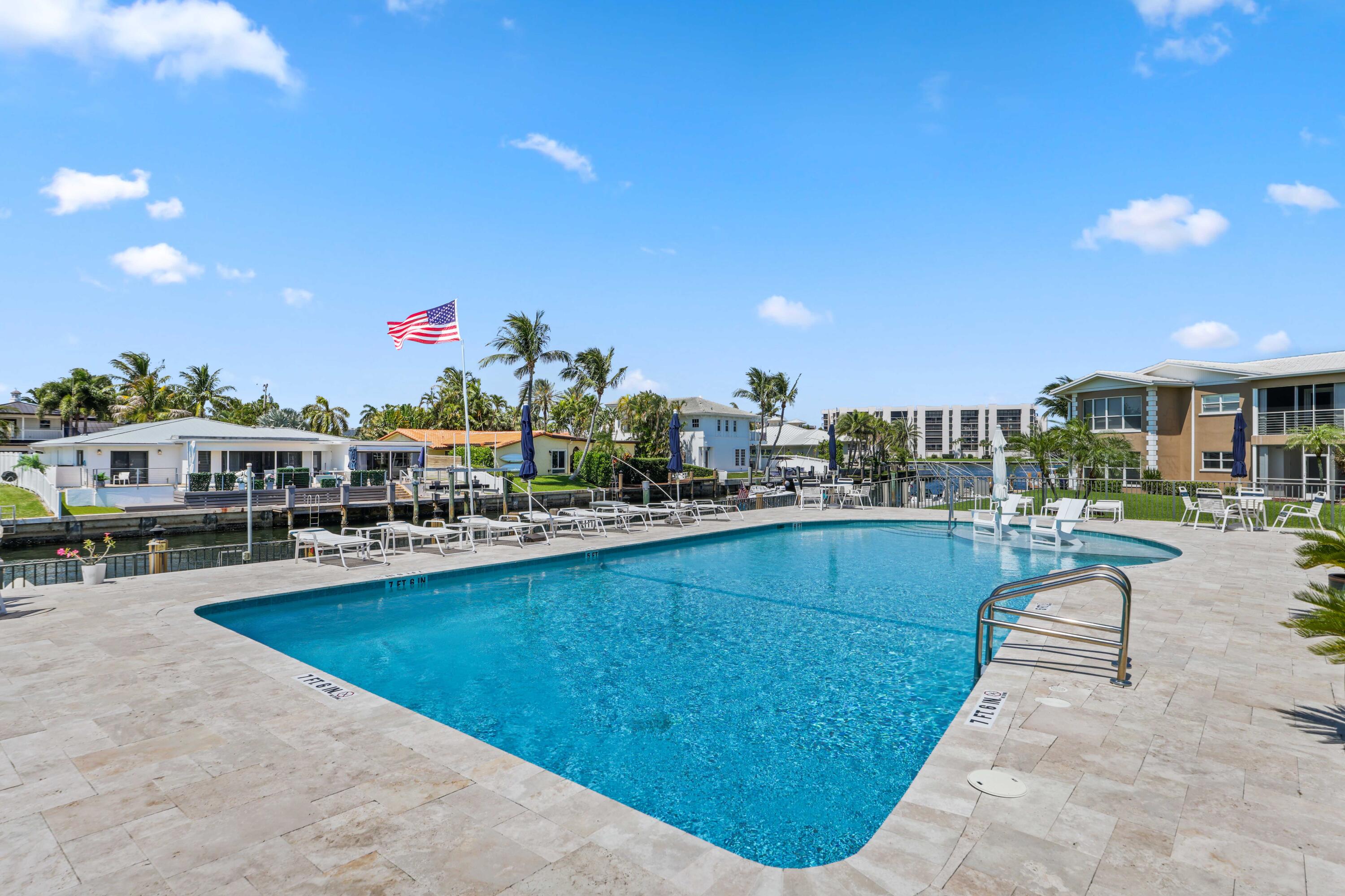 701 Harbour Drive, Unit 103 Boca Raton, FL 33431 - Photo 27 of 39 a view of a swimming pool and lounge chairs