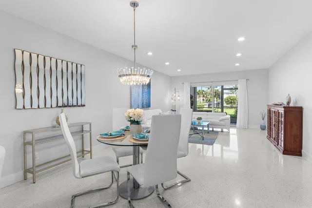 a dining room with furniture a chandelier and wooden floor