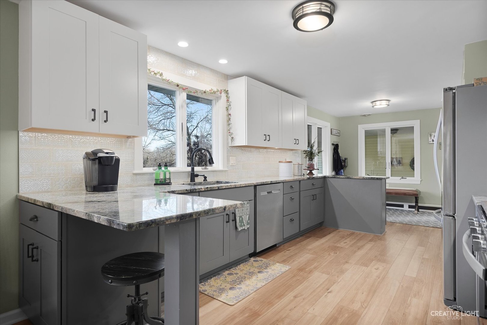 991 Hillcrest Road Elgin, IL 60123 - Photo 11 of 35 a kitchen with kitchen island granite countertop a sink cabinets and wooden floor