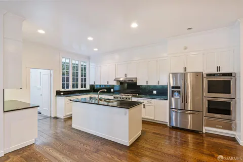 a kitchen with stainless steel appliances kitchen island granite countertop a stove a sink and a microwave