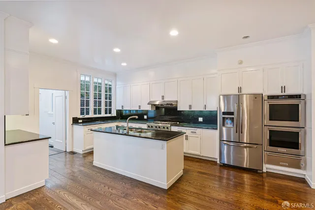 a kitchen with stainless steel appliances kitchen island granite countertop a stove a sink and a microwave