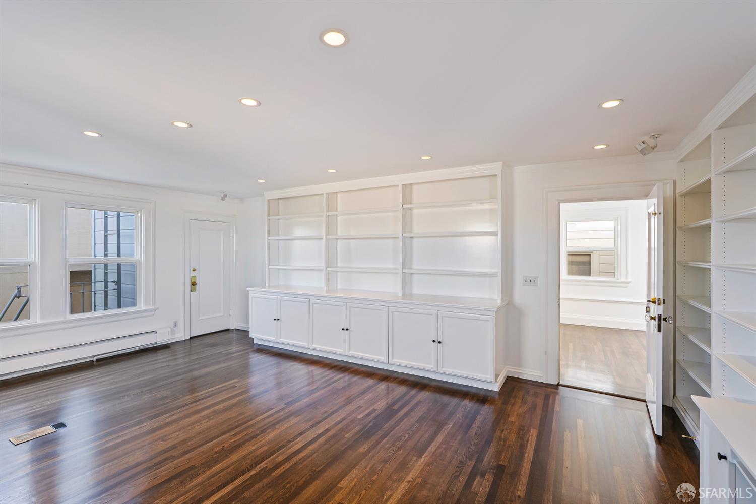 2521 Broadway San Francisco, CA 94115 - Photo 39 of 74 an empty room with wooden floor & cabinet and windows