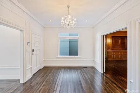 an empty room with wooden floor fireplace and windows
