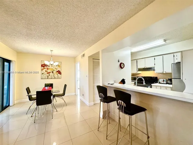 a kitchen with a sink and chairs