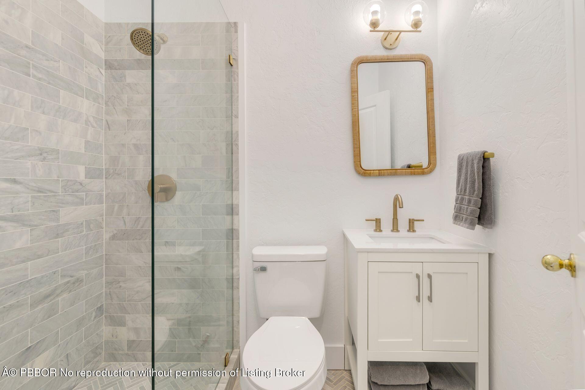 3020 Vincent Road West Palm Beach, FL 33405 - Photo 13 of 56 a bathroom with a toilet sink vanity and mirror