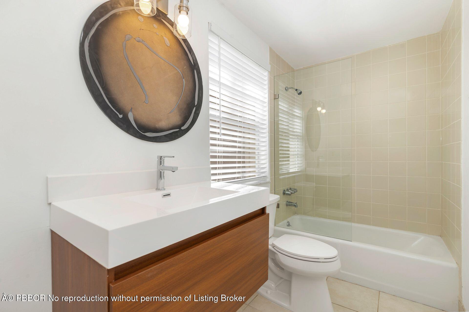 3020 Vincent Road West Palm Beach, FL 33405 - Photo 27 of 56 a bathroom with a sink a toilet and a mirror