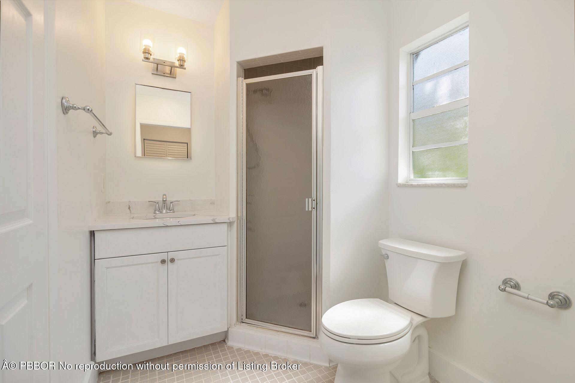3020 Vincent Road West Palm Beach, FL 33405 - Photo 30 of 56 a bathroom with a granite countertop toilet sink and mirror