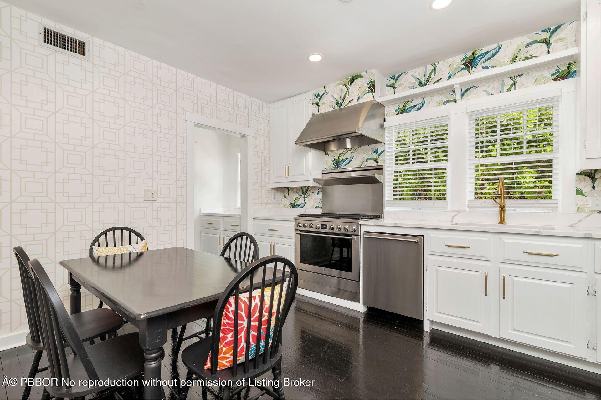 3020 Vincent Road West Palm Beach, FL 33405 - Photo 9 of 56 a kitchen with stainless steel appliances granite countertop a stove a kitchen island a dining table and chairs