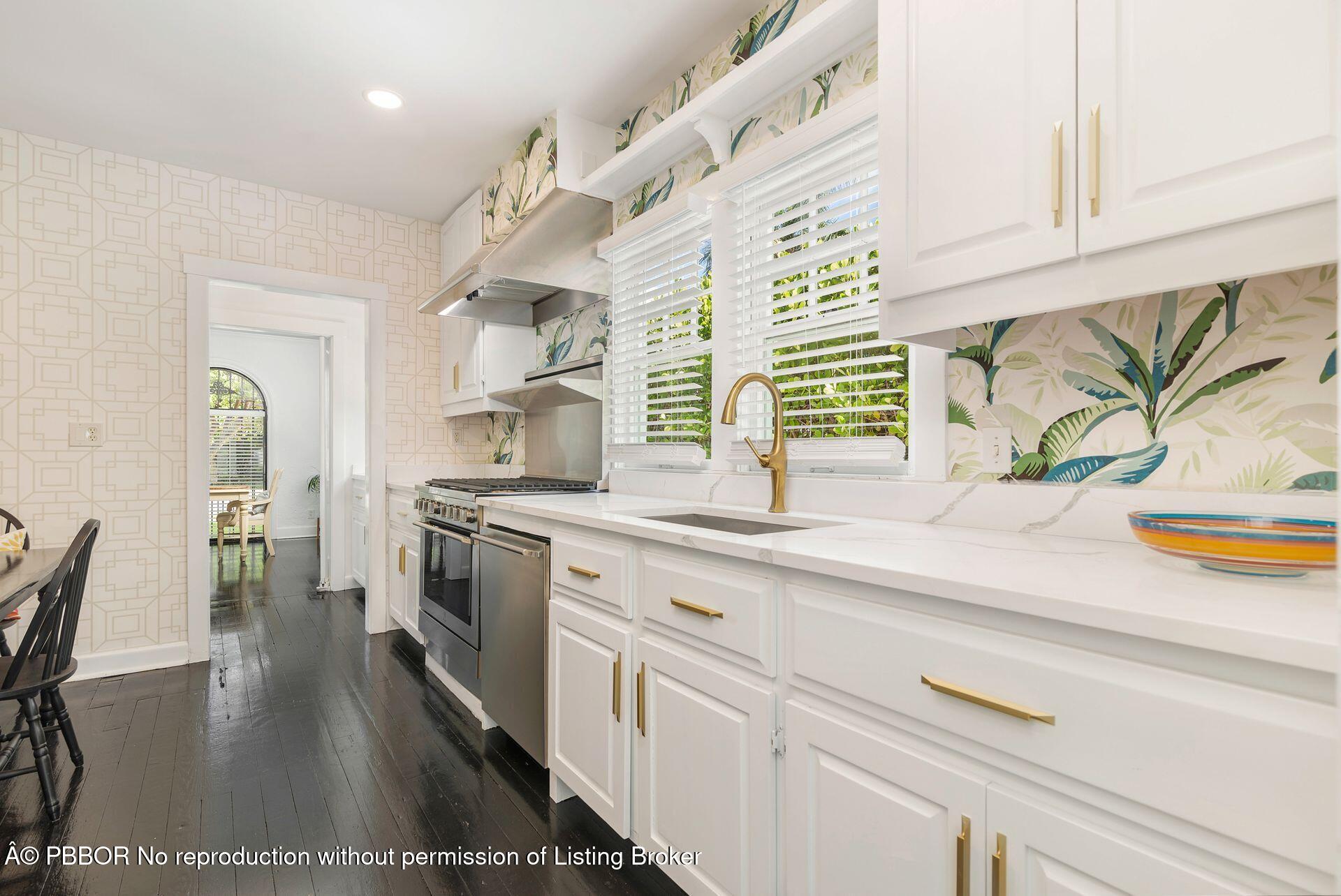 3020 Vincent Road West Palm Beach, FL 33405 - Photo 10 of 56 a kitchen with stainless steel appliances granite countertop a sink a stove and a wooden floors