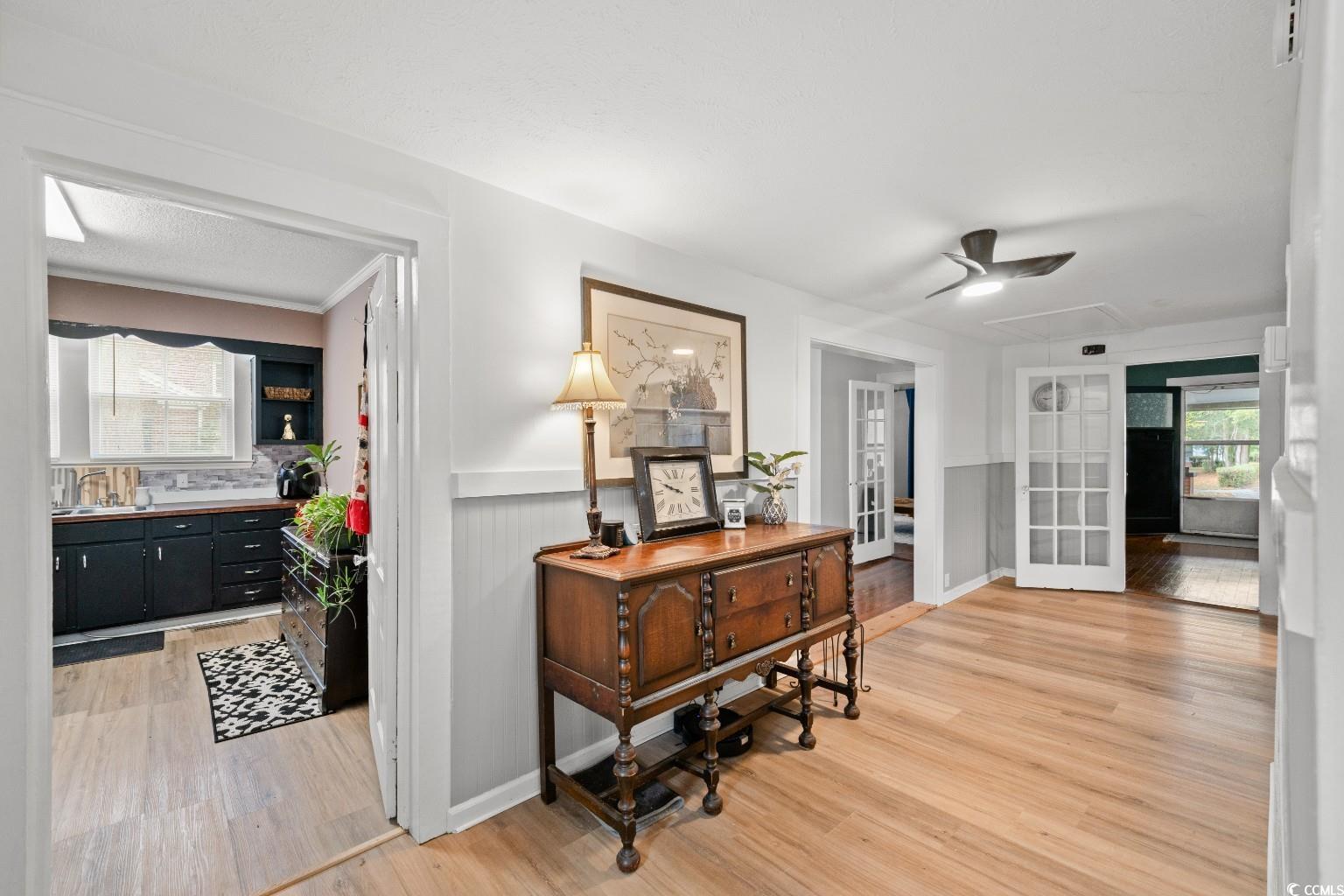 222 East Wine Street Mullins, SC 29574 - Photo 18 of 40 Hall featuring healthy amount of natural light, light wood-style floors, a wainscoted wall, and attic access
