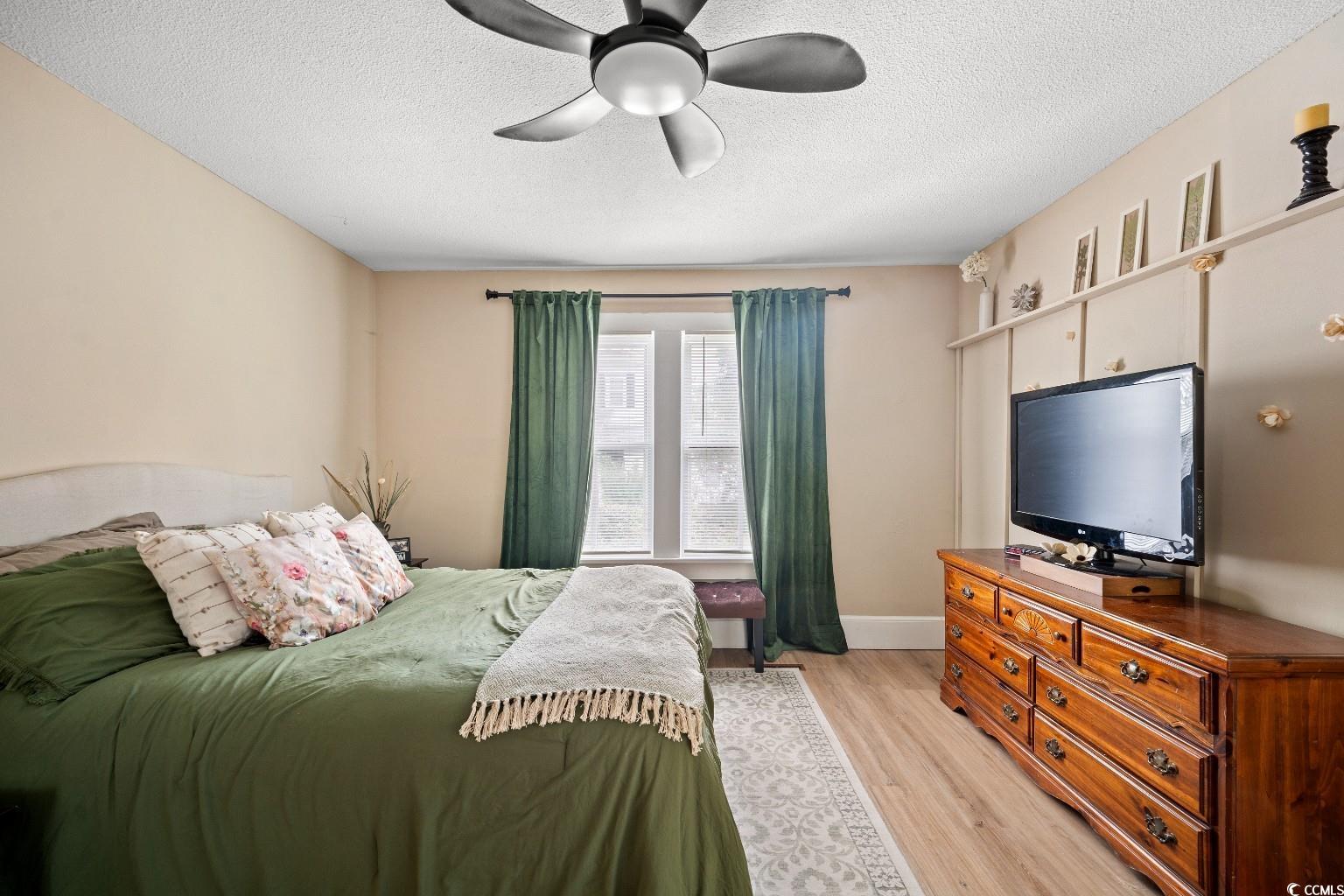 222 East Wine Street Mullins, SC 29574 - Photo 24 of 40 Bedroom featuring light wood-type flooring, a textured ceiling, and a ceiling fan