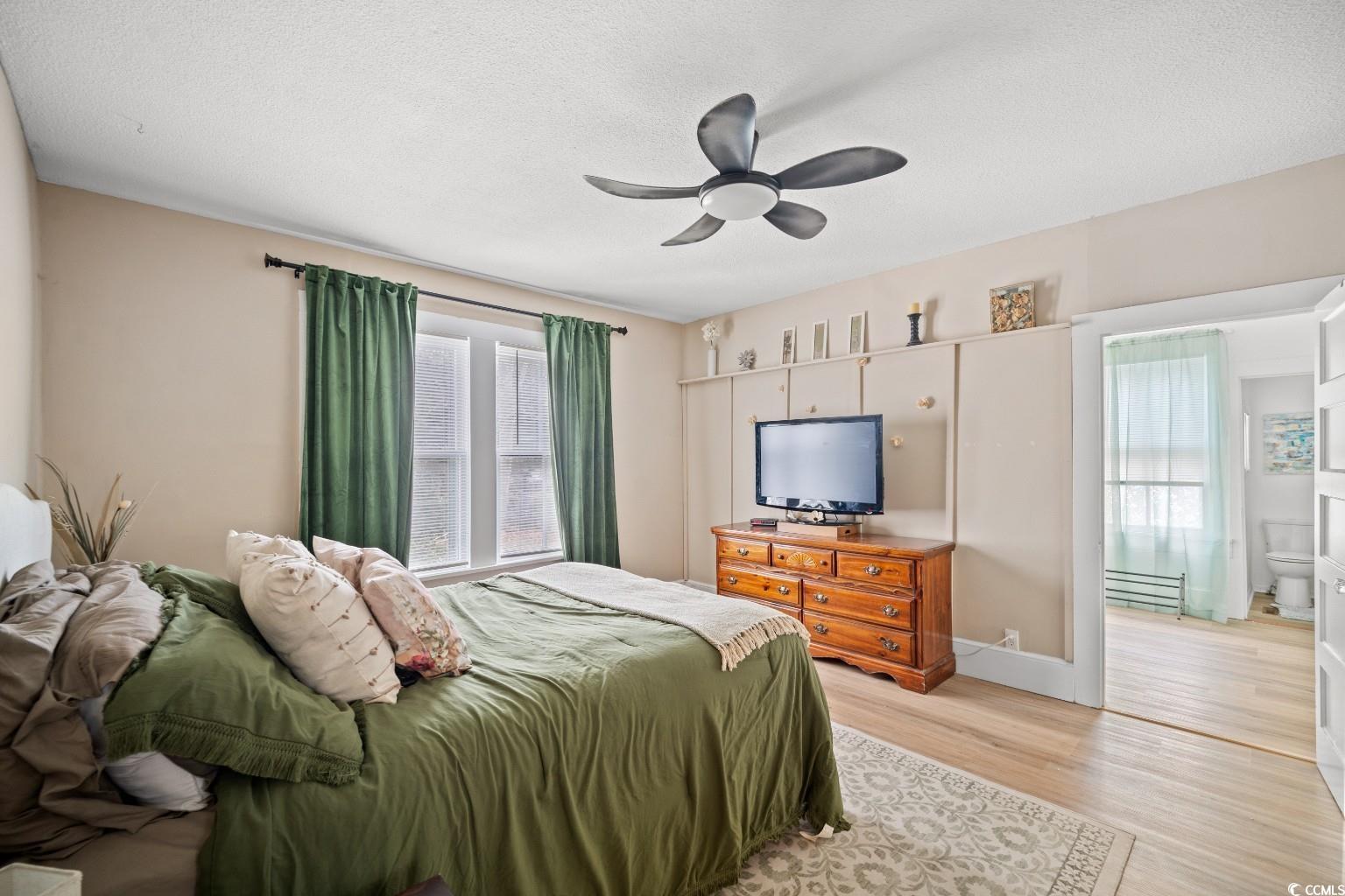 222 East Wine Street Mullins, SC 29574 - Photo 26 of 40 Bedroom featuring light wood-style floors, a ceiling fan, and a textured ceiling