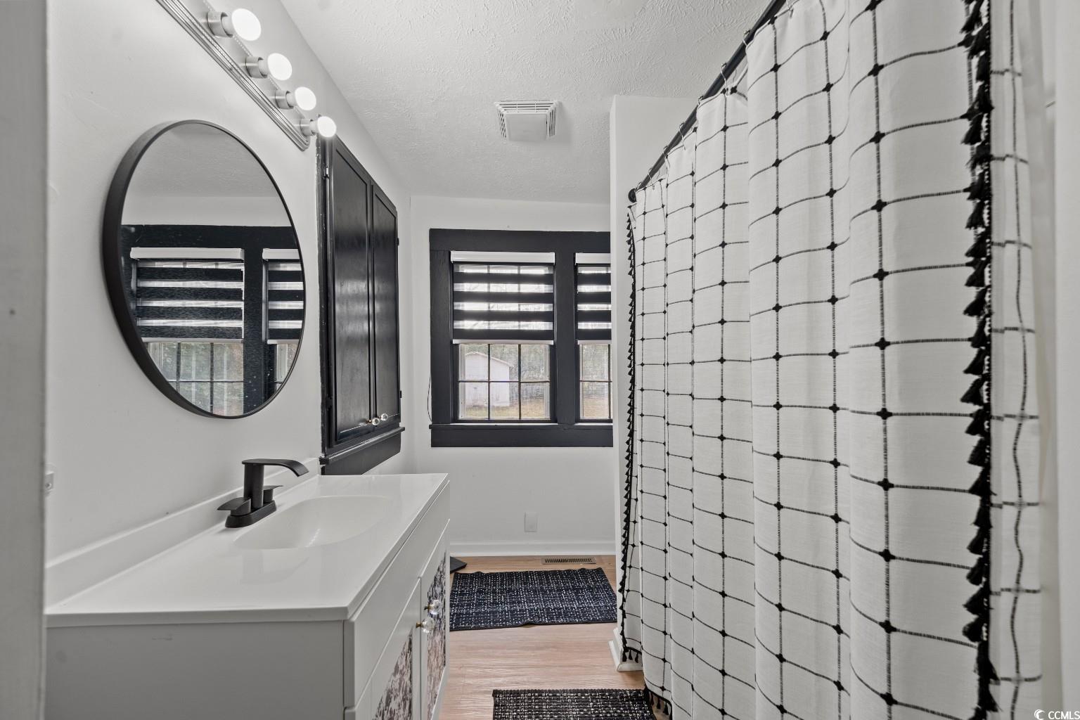 222 East Wine Street Mullins, SC 29574 - Photo 30 of 40 Full bath featuring vanity, a shower with shower curtain, a textured ceiling, and light wood finished floors