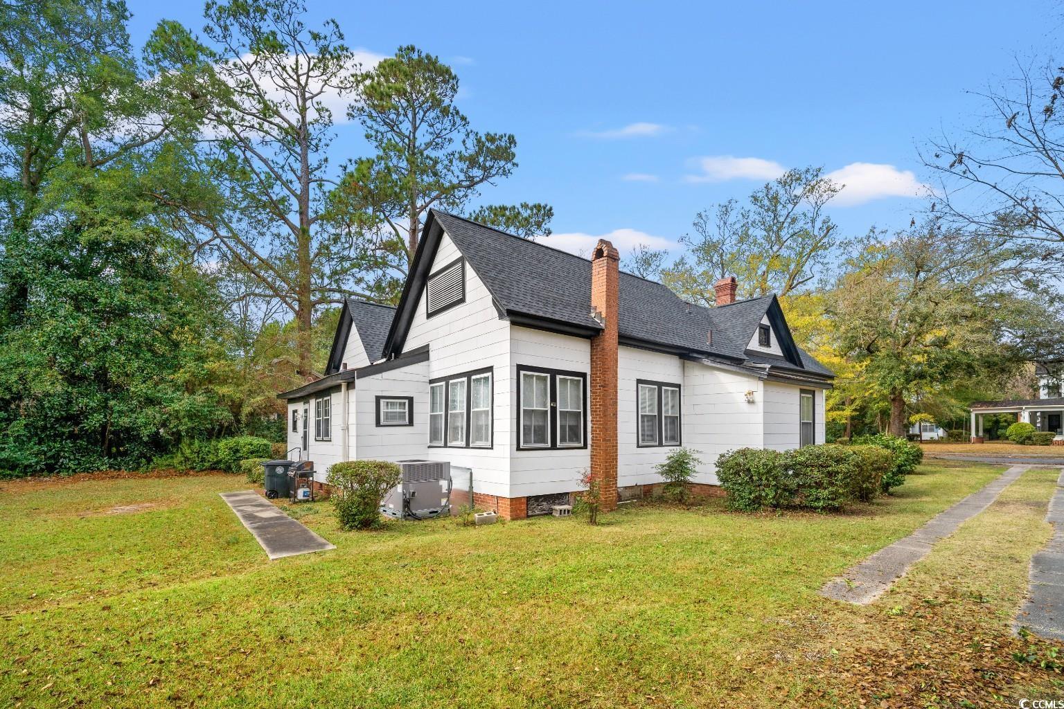 222 East Wine Street Mullins, SC 29574 - Photo 31 of 40 View of side of home featuring a chimney, a lawn, and a shingled roof