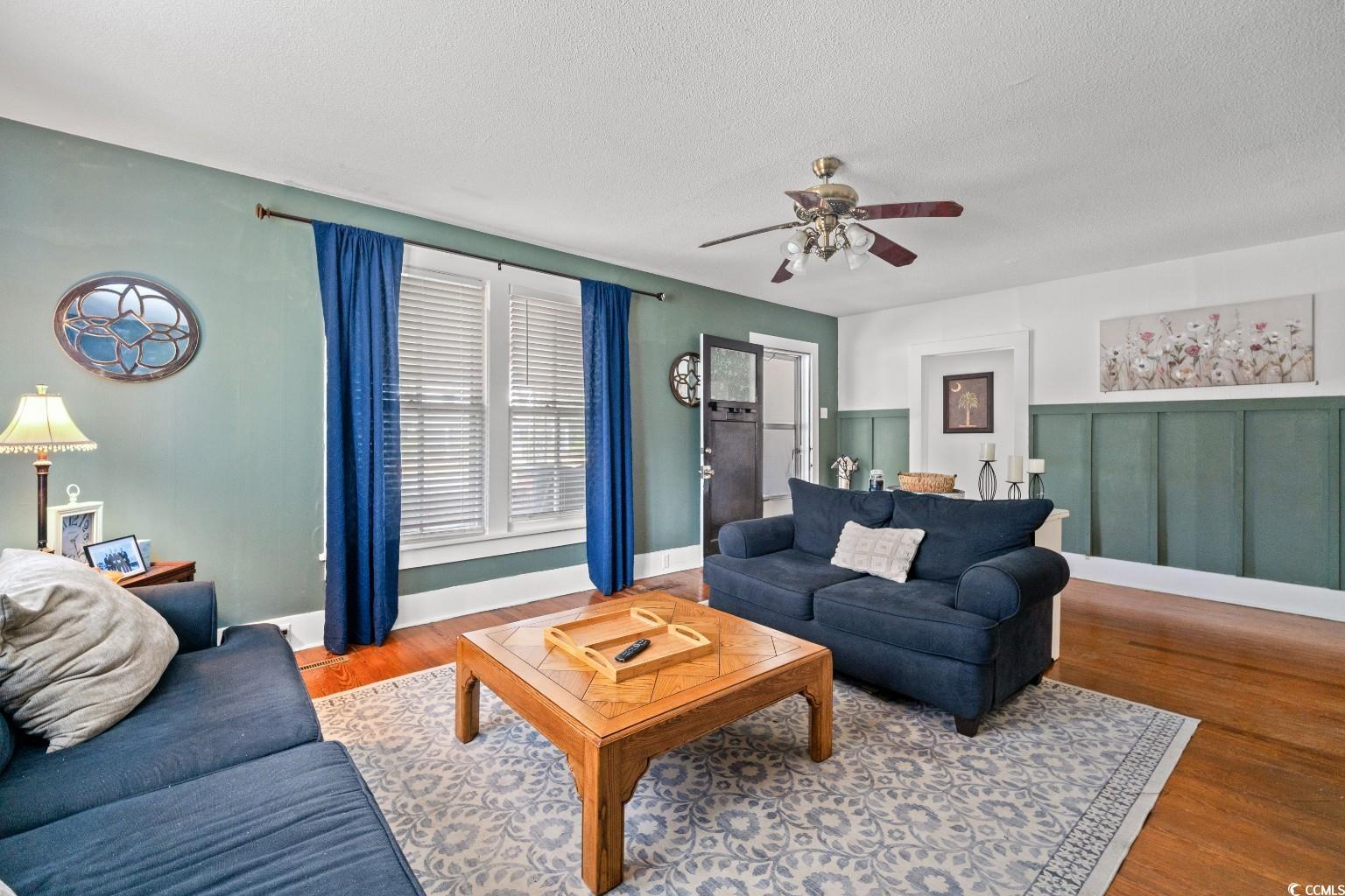 222 East Wine Street Mullins, SC 29574 - Photo 9 of 40 Living area featuring wood finished floors, a textured ceiling, and a ceiling fan
