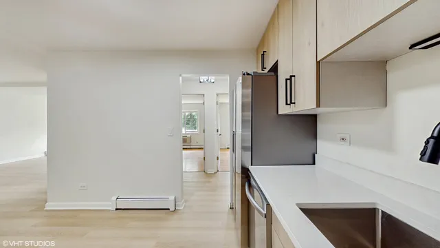 a kitchen with cabinets and wooden floor