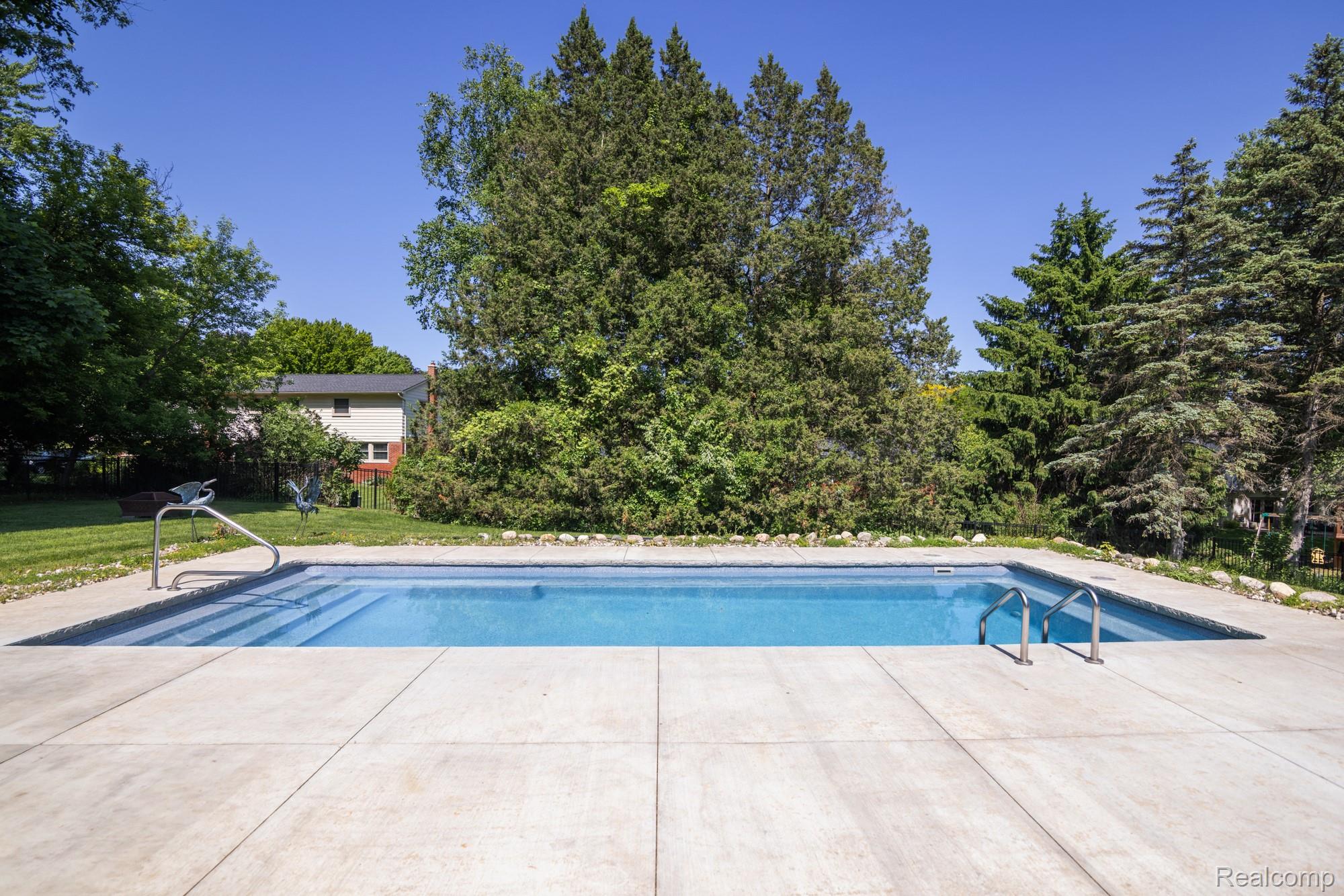 724 Sandstone Drive Rochester, MI 48309 - Photo 53 of 60 Rectangular in-ground pool featuring integrated steps and dual stainless steel handrails
