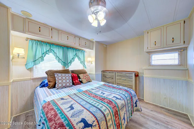 a bedroom with a large bed and a chandelier