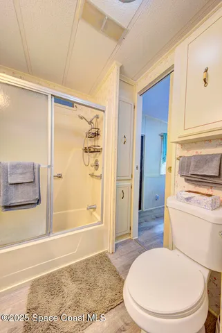 a bathroom with a toilet and a shower