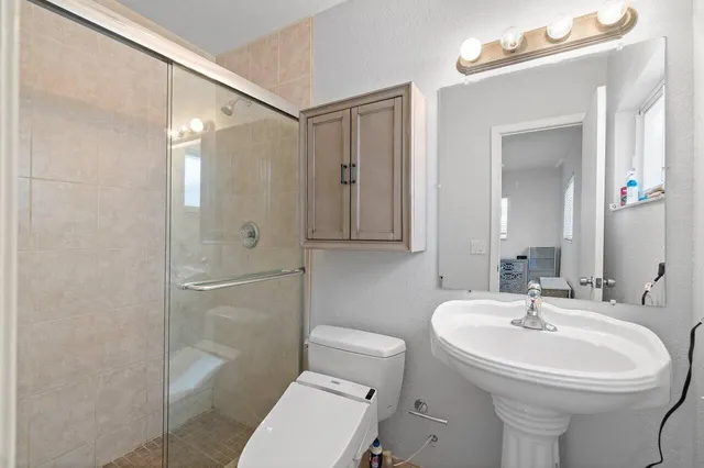 a bathroom with a sink toilet and shower