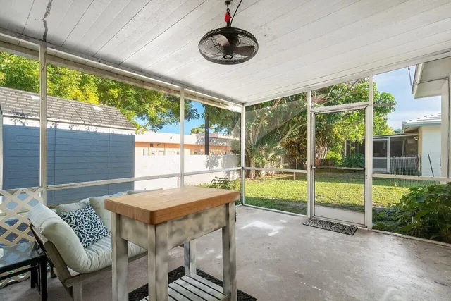 a dining room with furniture and a floor to ceiling window