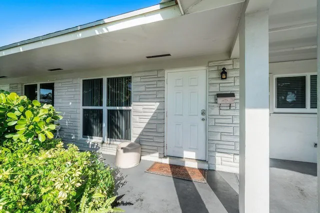 a view of a balcony with a potted plant and floor to ceiling window