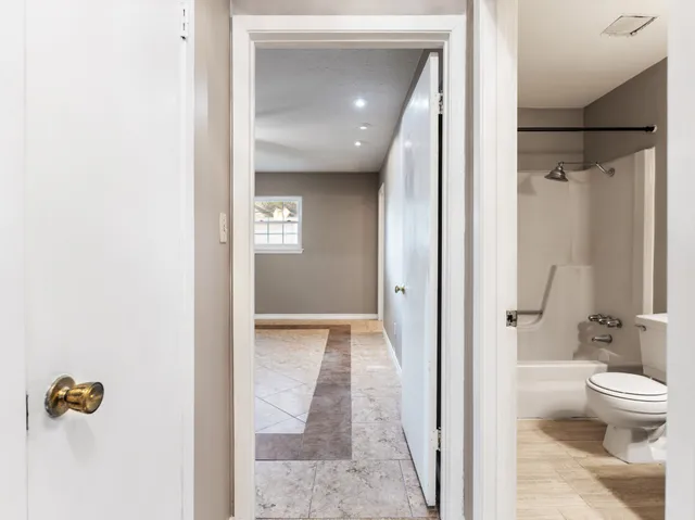 a bathroom with a glass door shower and a toilet