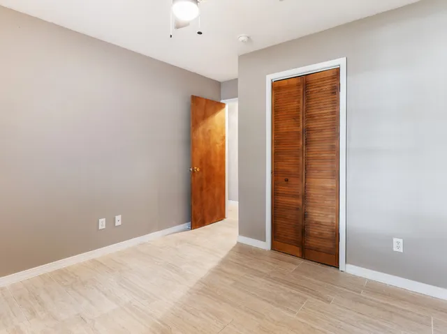 an empty room with wooden floor and entrance