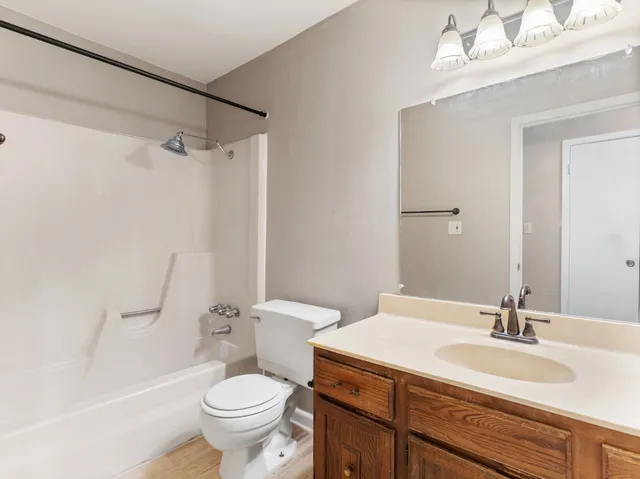 a bathroom with a granite countertop sink toilet a large mirror and shower