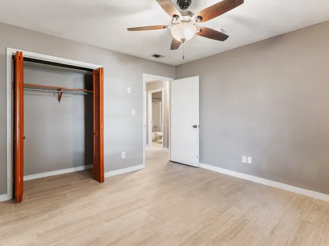 an empty room with fan and entrance
