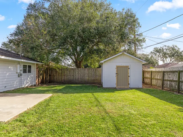a view of a backyard with a house and large tree