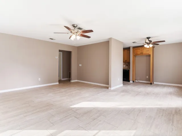 a view of a livingroom with a ceiling fan and window