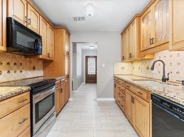 a kitchen with stainless steel appliances granite countertop a stove and a microwave