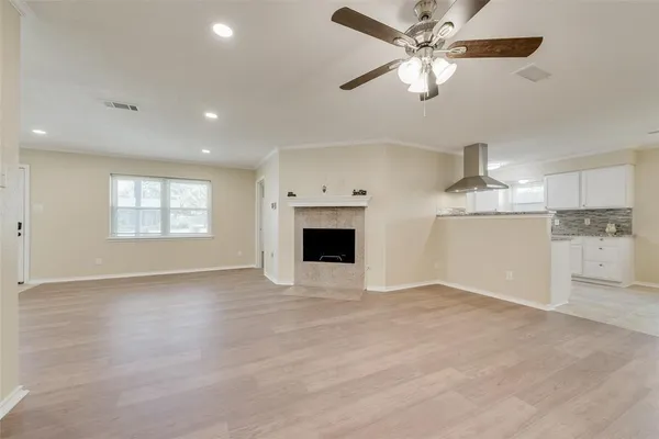 an empty room with windows and fireplace