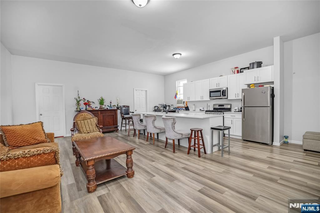 512 Monastery Place, Unit 3 Union City, NJ 07087 - Photo 2 of 11 a living room with stainless steel appliances furniture and a wooden floor