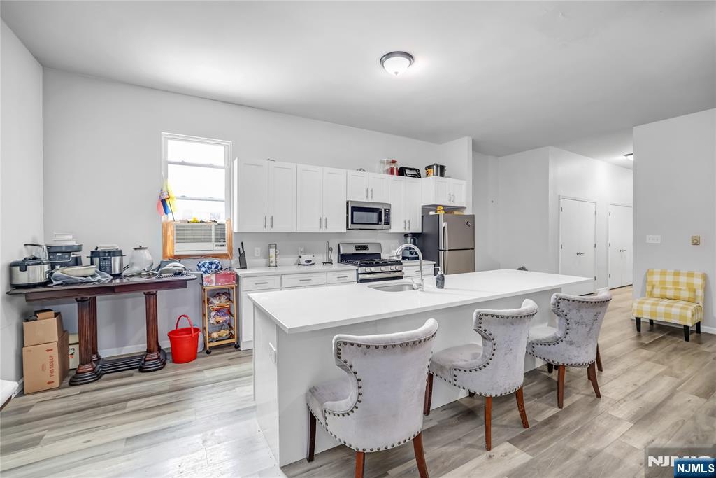 512 Monastery Place, Unit 3 Union City, NJ 07087 - Photo 4 of 11 a kitchen with stainless steel appliances a table and chairs in it
