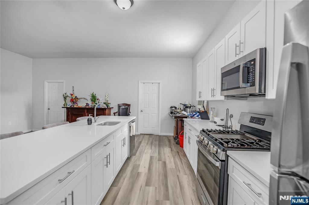 512 Monastery Place, Unit 3 Union City, NJ 07087 - Photo 6 of 11 a kitchen with stainless steel appliances a stove microwave and cabinets