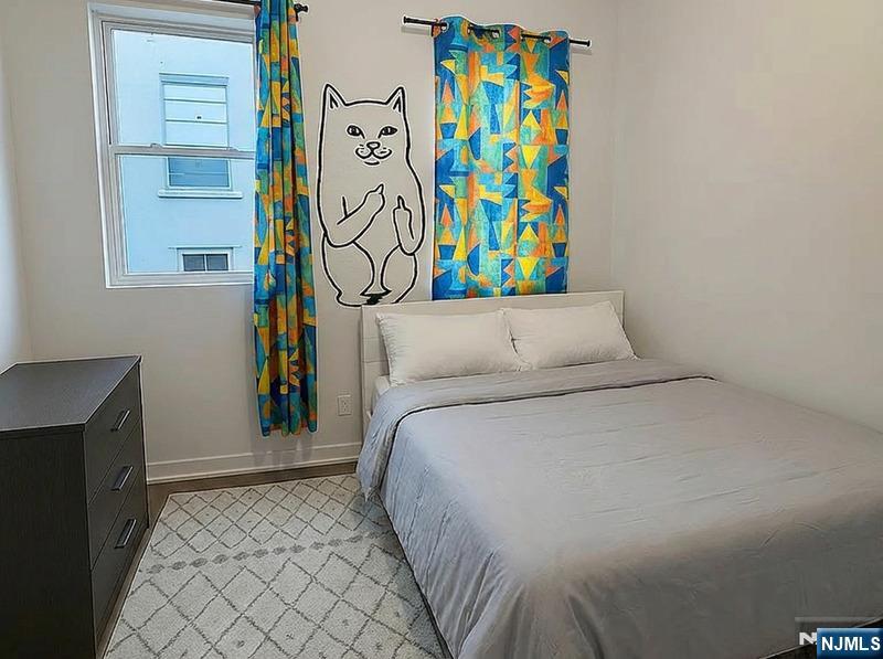 512 Monastery Place, Unit 3 Union City, NJ 07087 - Photo 9 of 11 a bedroom with a bed and painting on the wall