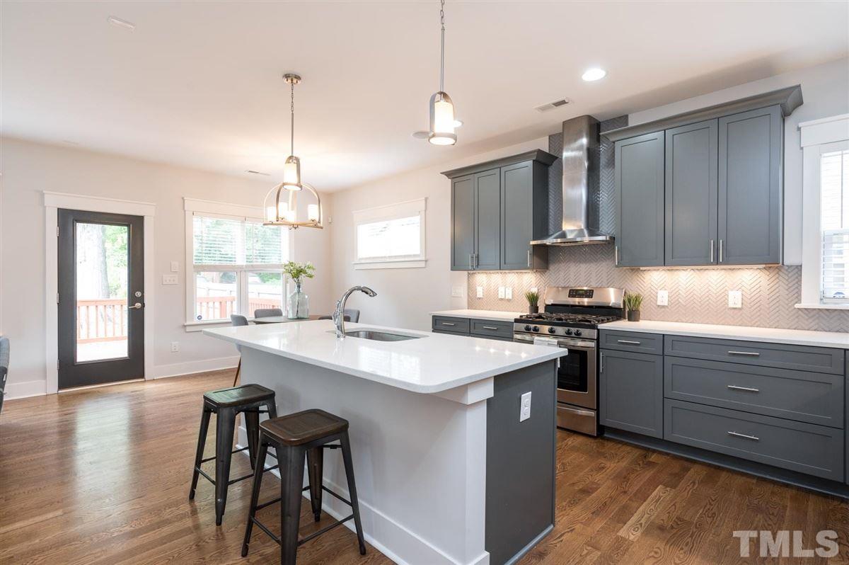 1010 Gregg Street Raleigh, NC 27601 - Photo 3 of 22 Gourmet kitchen featuring quartz countertops, designer cabinetry, herringbone glass tile backsplash and stainless steel appliances.