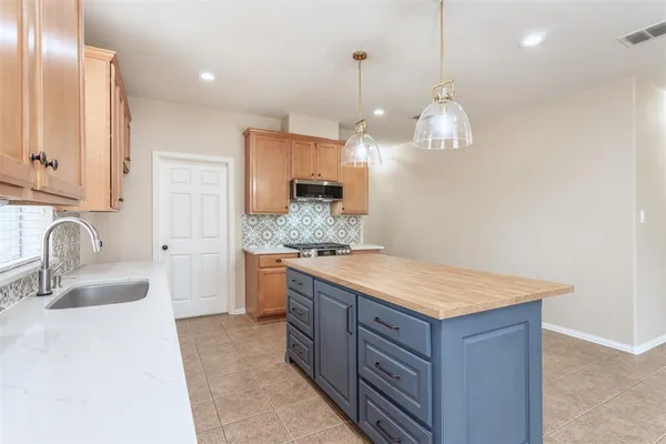 a kitchen with a sink a counter space appliances and cabinets