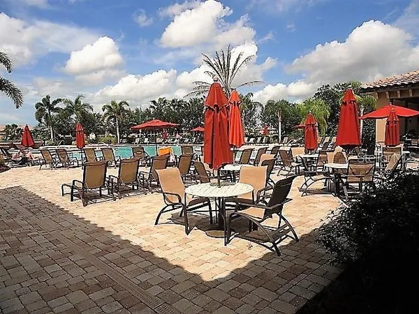 a view of a patio with dining table and chairs with a small yard